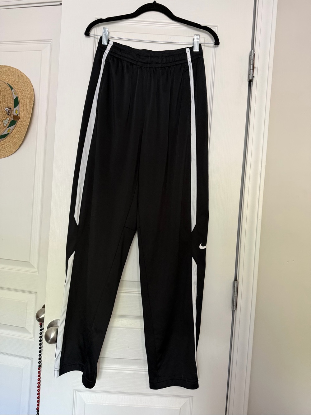 Nike black men’s track pants with white side stripes, size M